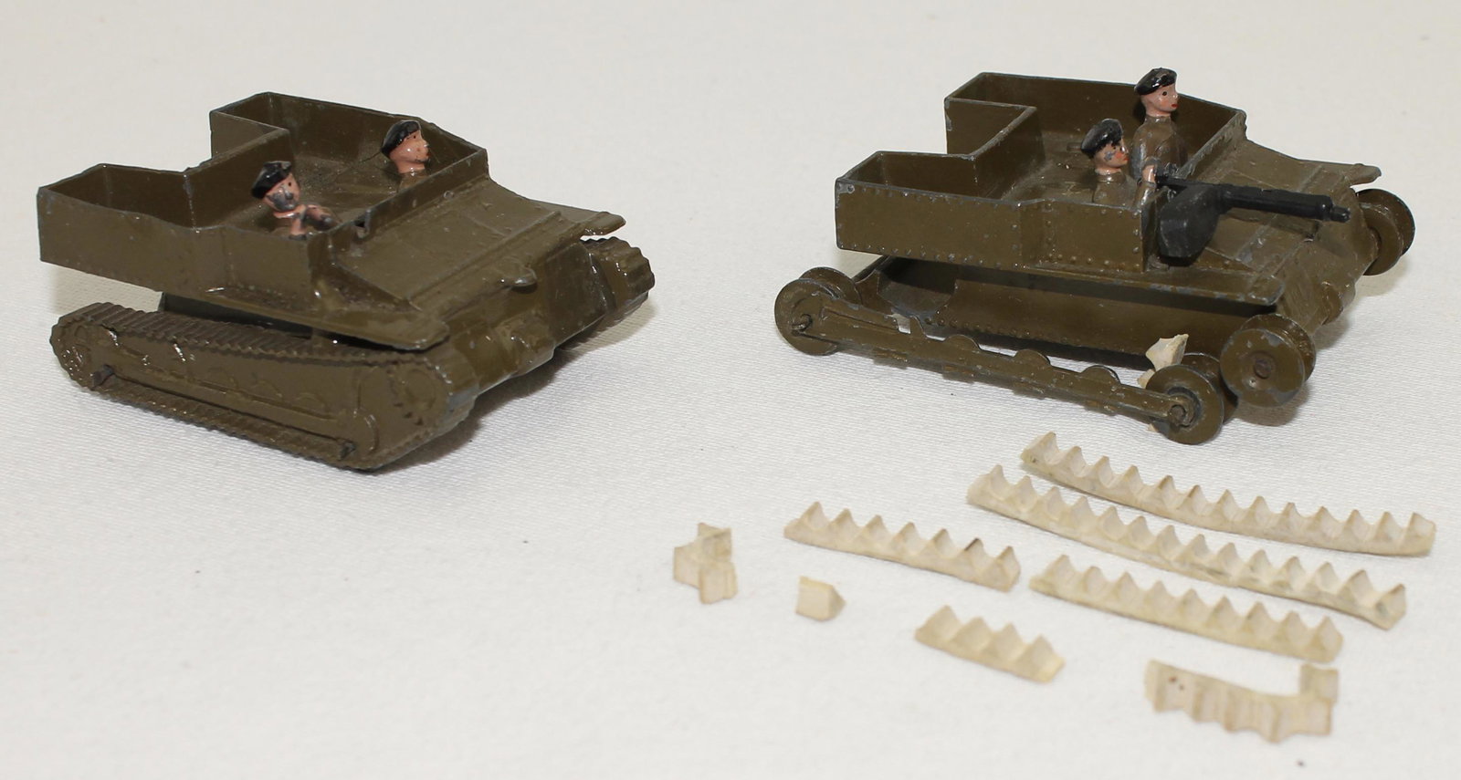Britains Lot Tanks of the Royal Tank Corps: With Crew. Lot includes #1202 Carden-Lloyd Tank with White Rubber Treads and #1202 with Cast Treads. 7 Pieces. Condition Very Good to Good. White Treads Broken and Distressed. One Lacking Machine Gun.