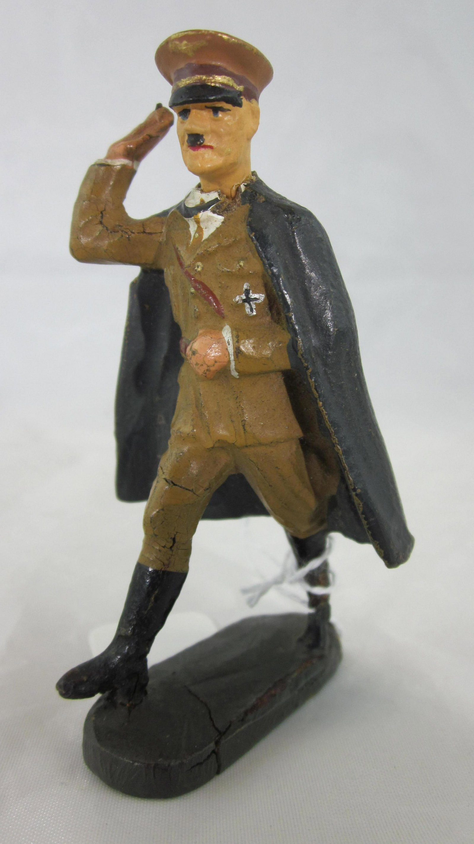 Elastolin Porcelain Head Hitler In Cape.: UNBOXED 7cm Adolf Hitler, fixed arm, saluting in black cloak. 1 piece. Condition very good, crack in left boot and throat, repaired rear neck of cape. Paint is excellent, circa 1930s. See page 79 in R