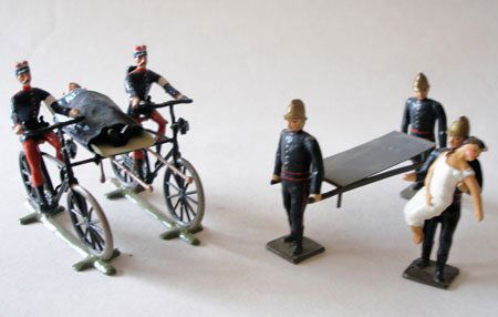 Mignot Firemen with Stretcher, casualty, etc.: Mignot Firemen with Stretcher and casualty and Dual French Army 1890 Cyclists in the modern style of Heyde carrying Stretcher between Cycles. Circa 1950.