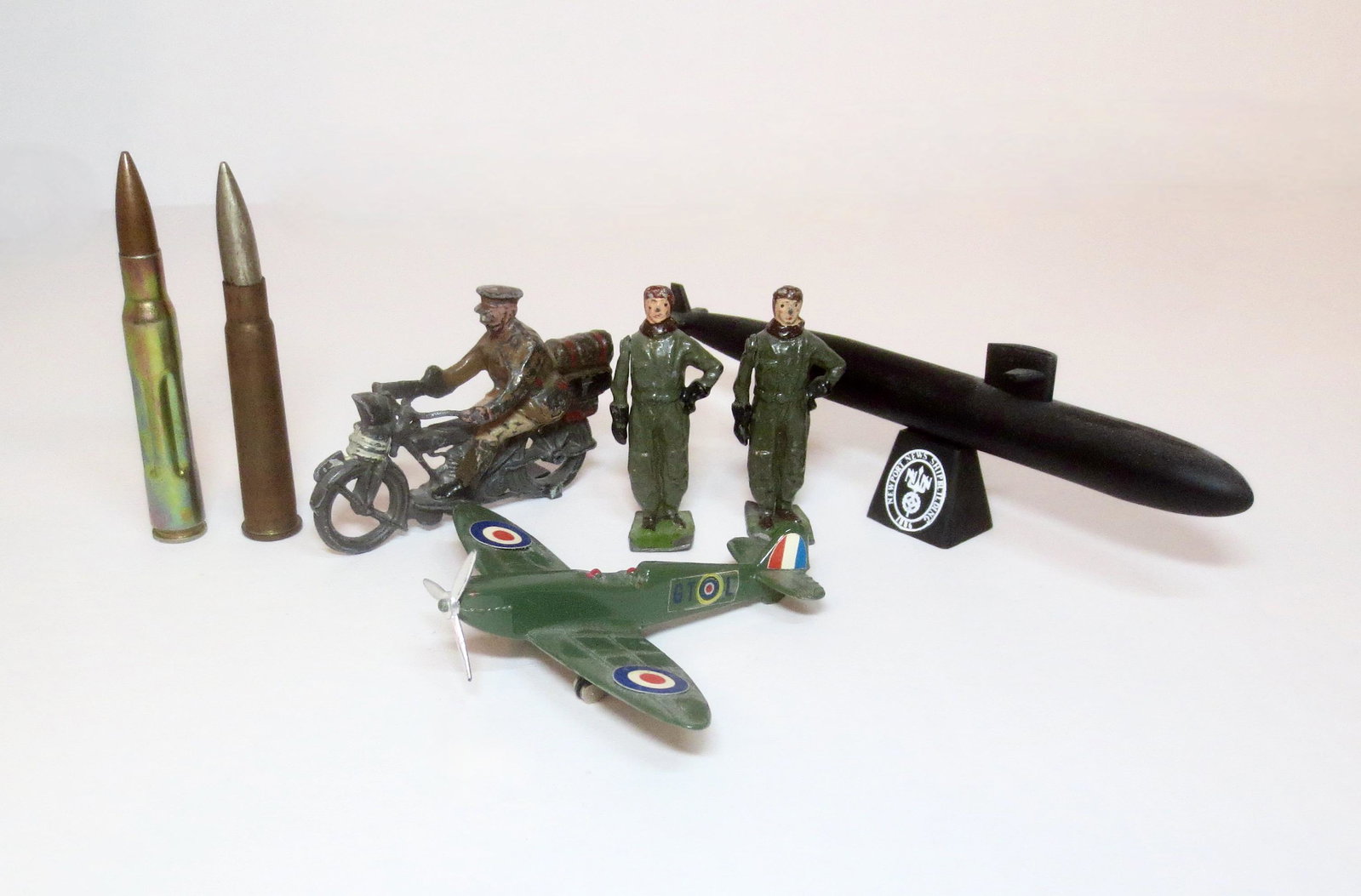 Military Assortment: Britains Pilots & Motorcycle Dispatch rider (missing part of base). Rifle shells and diecast airplane in good condition. Plus a Newport News ship building plastic submarine. Unboxed.