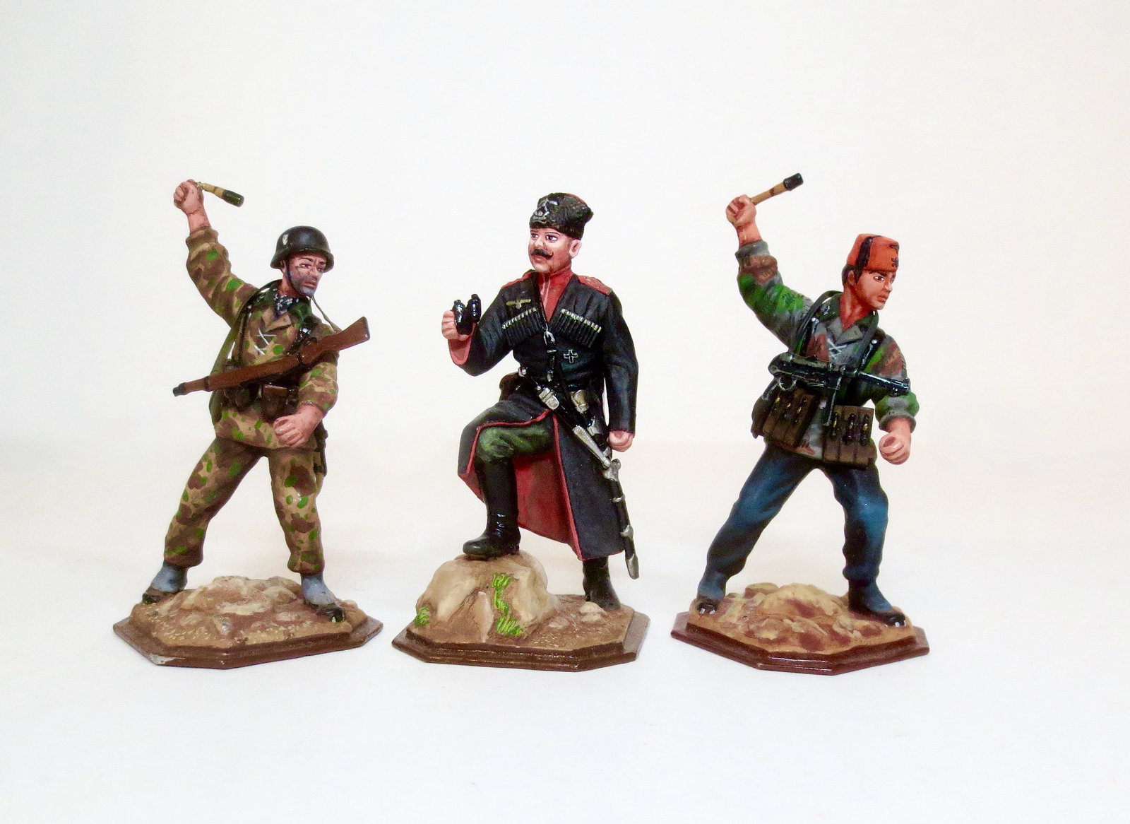 St. Petersburg Trio Of WWII Soldiers: Bosnian SS with Grenade, Handschar Division Red/Orange Fez with Machine gun slung on back, Croatian SS Kama Division with Grenade, and Officer of The Cossack Cavalry 4th Kuban Regiment. 65mm tall. Stu