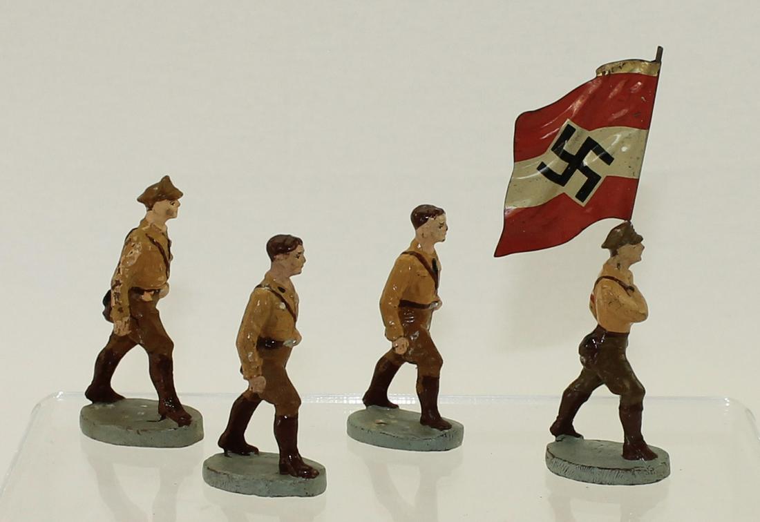 Elastolin Lot Hitler Youth Marching: Elastolin Germany. Summer Uniform. Lot includes #36/51 Flagbearer with Tin Flag and (3) of #36/12 Marching. Circa 1937.Composition. 4 Pieces. Condition Good to Very Good. No Box.