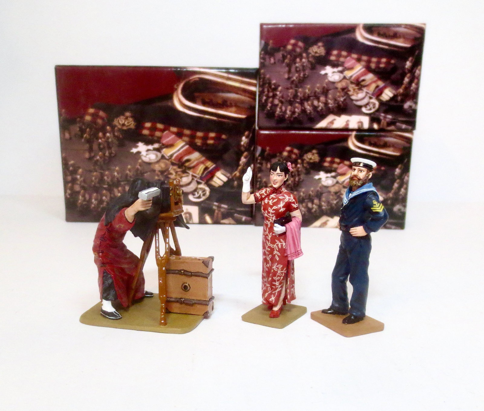 King & Country Streets of Old Hong Kong Figures: The Photographer Set #HK147, Shanghai Lady in Red #HK257, and Sailor #204. 3 pieces. Mint condition. Boxes excellent.
