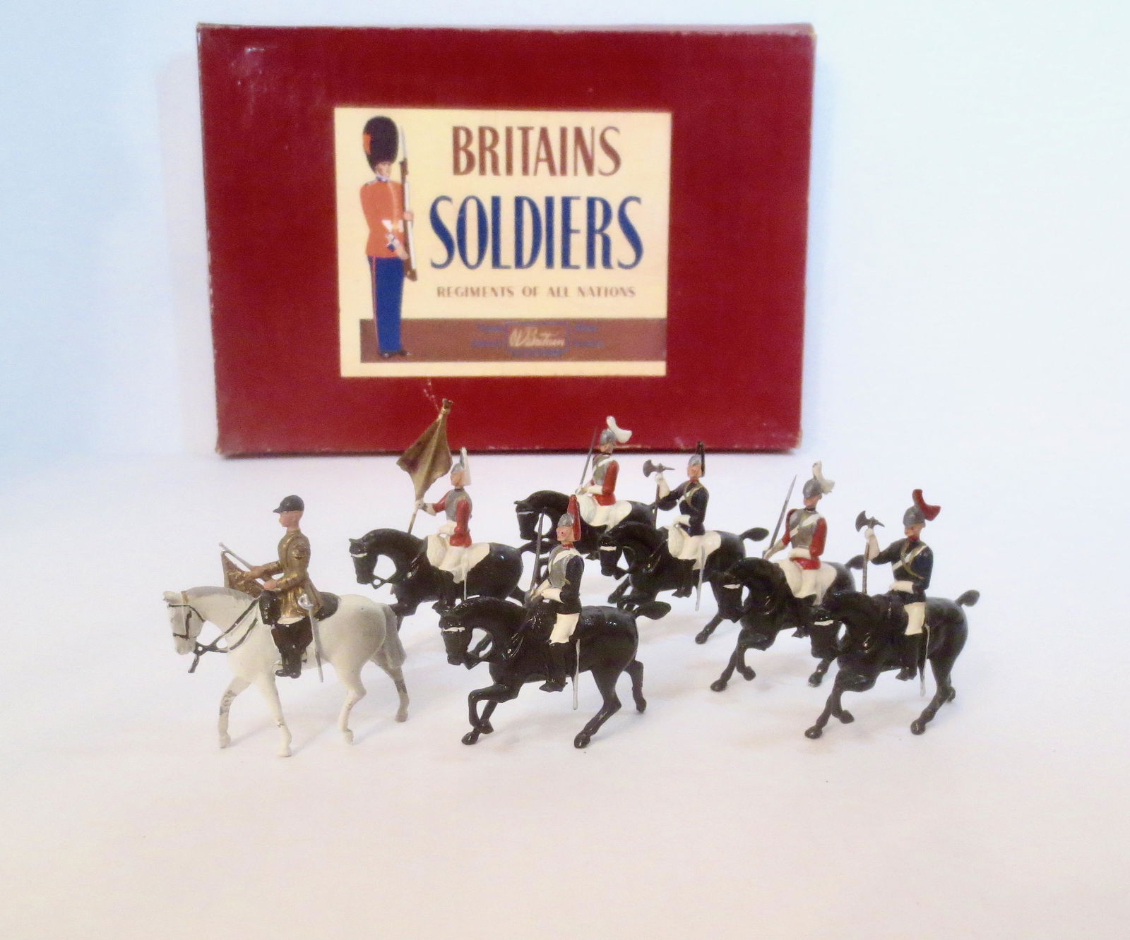 Britains #2067 The Sovereigns Standard: Sovereigns Standard with Trumpeter and Escort. Post war issue. 7 pieces. Near mint to excellent condition. Box fair (two top corner splits, bottom crushed on one side).