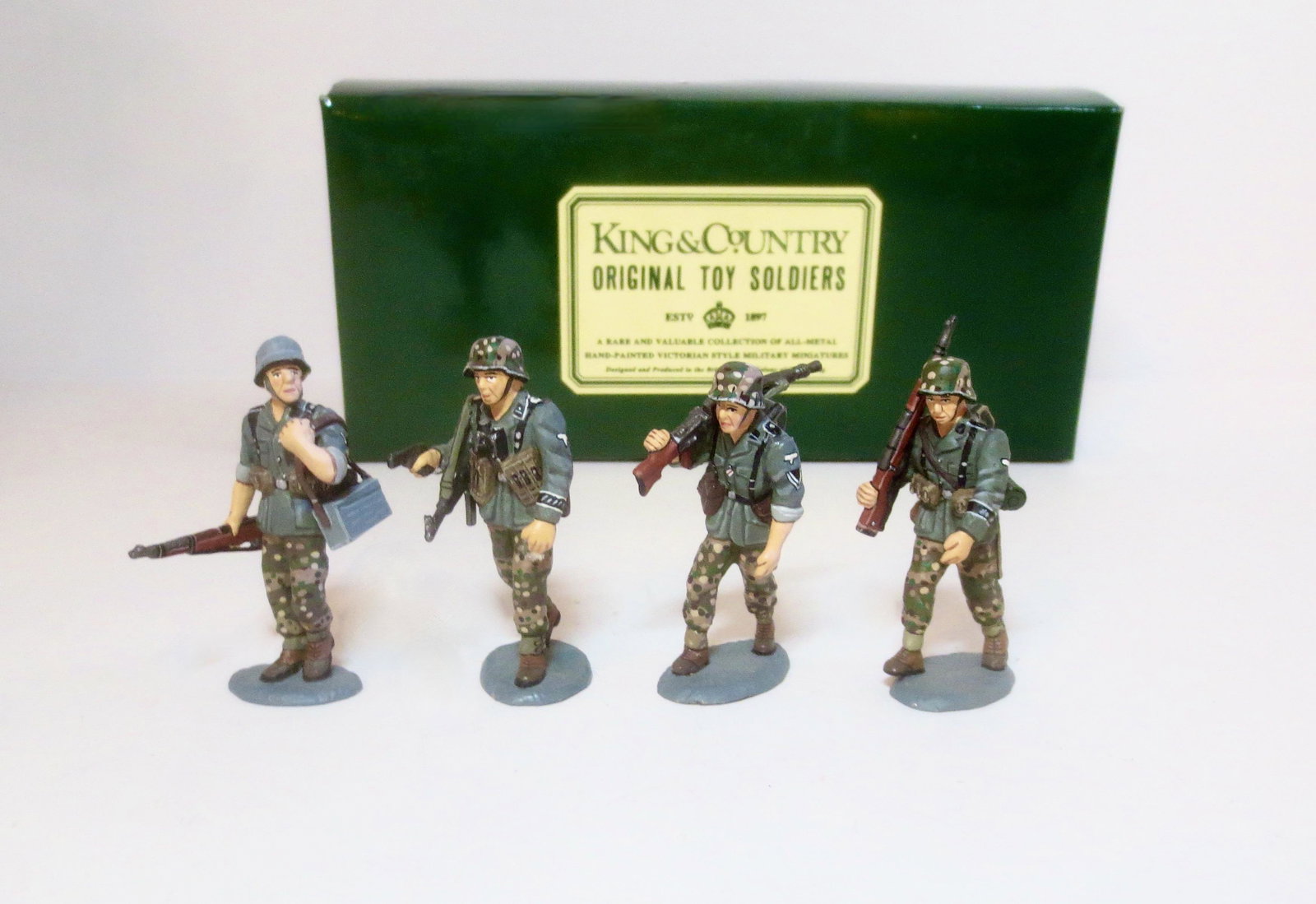 King & Country Three Advancing Panzer Grenadiers: With Officer. Retired set. 4 pieces. Mint to near mint condition. Box excellent.