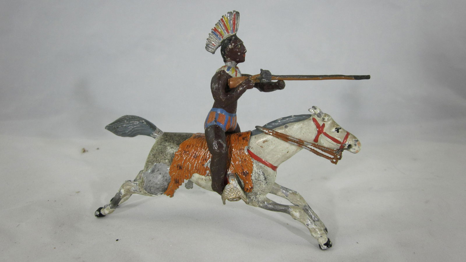Heyde Large Scale "Gym Short" Mounted Indian.: UNBOXED Size 00 "Gym short" Indian mounted at full gallop firing rifle. 1 piece. Condition very good, large paint chips to horse. Rare piece circa 1930. No box.