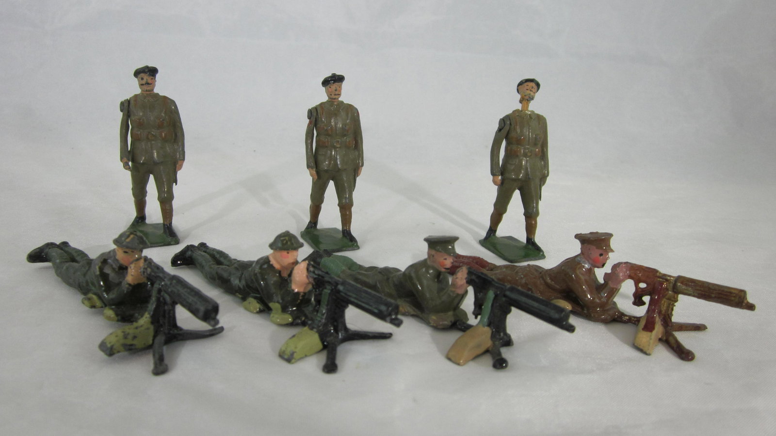 Britains British In Khaki Battledress Medley.: UNBOXED #194 early peaked cap lying machine gunner, 3 of #1318 machine gunners and 3 #1250 Royal Tank Corp. 7 pieces, condition good to excellent, peak cap #1318 missing 1 tripod leg of gun and 1 Tank