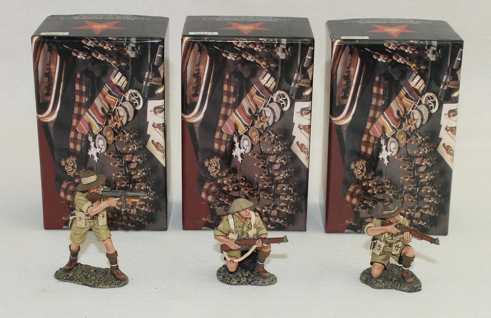 King & Country Lot Australian Troops: British Eighth Army. Lot includes Set #EA096 Australian Kneeling Firing, Set #EA098 Officer with Tommy Gun and Set #EA0128 Infantryman Kneeling. 3 Pieces. Condition Excellent. Boxes Excellent.