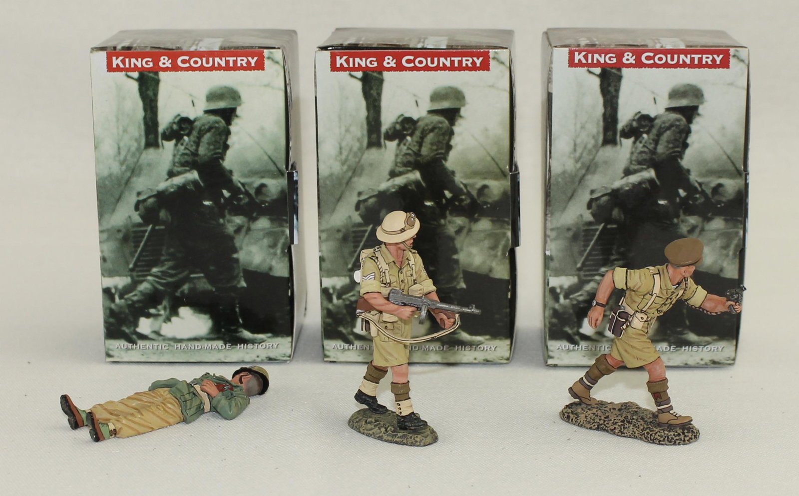 King & Country Lot British Infantry with Enemy: British Eighth Army. Lot includes Set #EA074 Afrika Korps Casualty, Set #EA079 British Officer with Revolver and Set #EA080 British Sergeant with Tommy Gun. 3 Pieces. Condition Excellent. Boxes Excell