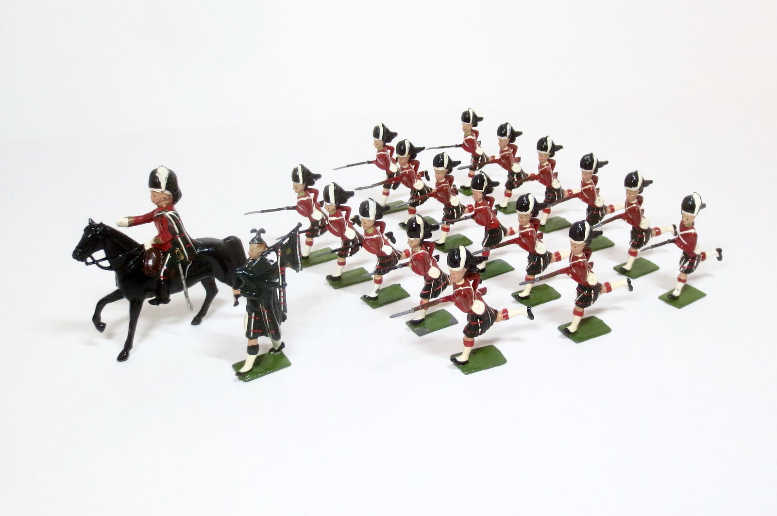 Britains from #2062 Seaforth Highlanders: Charging with Mounted Officer & Piper. Post war issue. 19 pieces. Near mint condition (one missing bayonet). Unboxed.