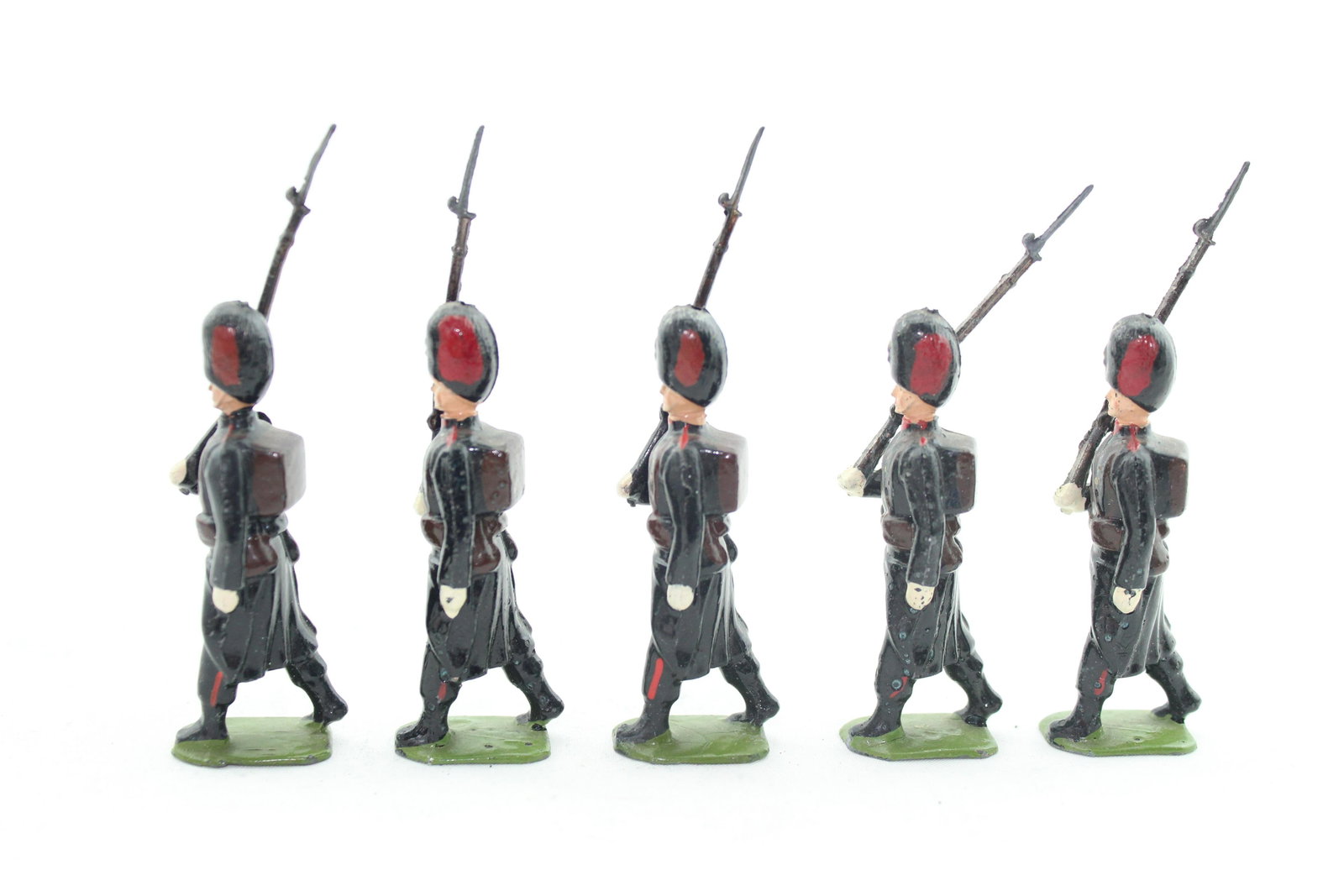 From Britains Set #2009 Belgian Grenadiers: Five pcs, postwar, troopers marching at slope, VG/E, embellished with red plumes, 1 loose rifle arm. No box.