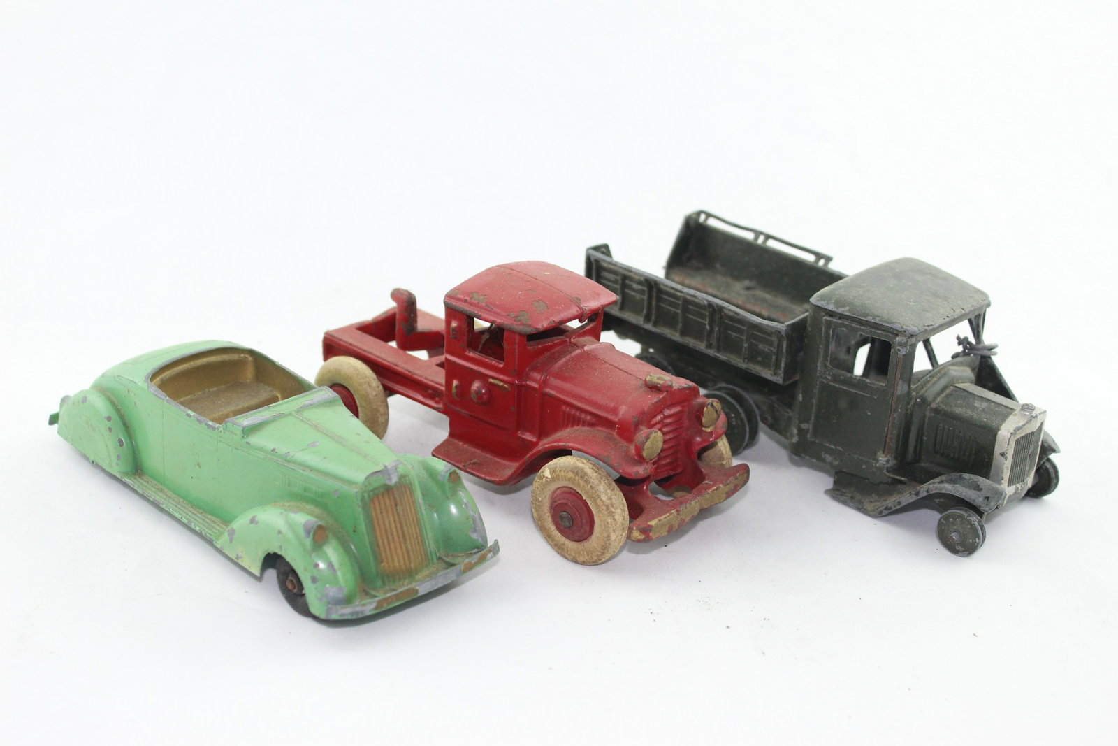 Vehicle Lot: Three pcs, 1930s-40s?, poor to fair condition, includes: Erie green car, red truck with worn, cracked tires, and Britains lorry/truck with broken door, missing tires.