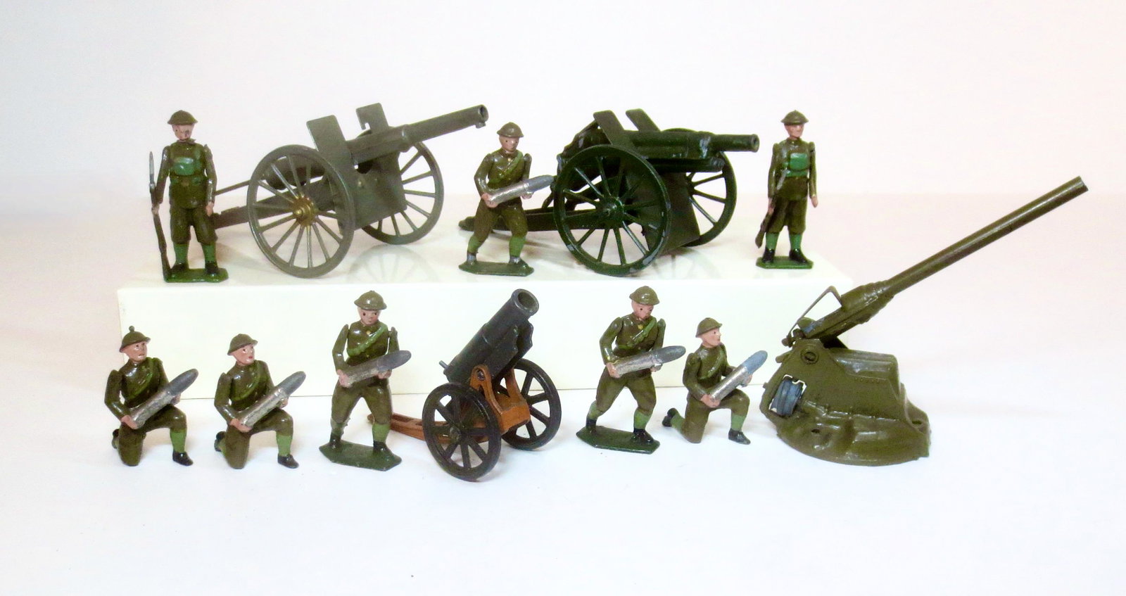 Britains From #1730 Royal Regiment Of Artillery: With two Sentrys, #1292 Field Artillery Gun, #1715 Mobile A.A. Gun, one American made gun, and one Mignot cannon. 12 pieces. Excellent to good condition (Mignot gun not working). Unboxed.