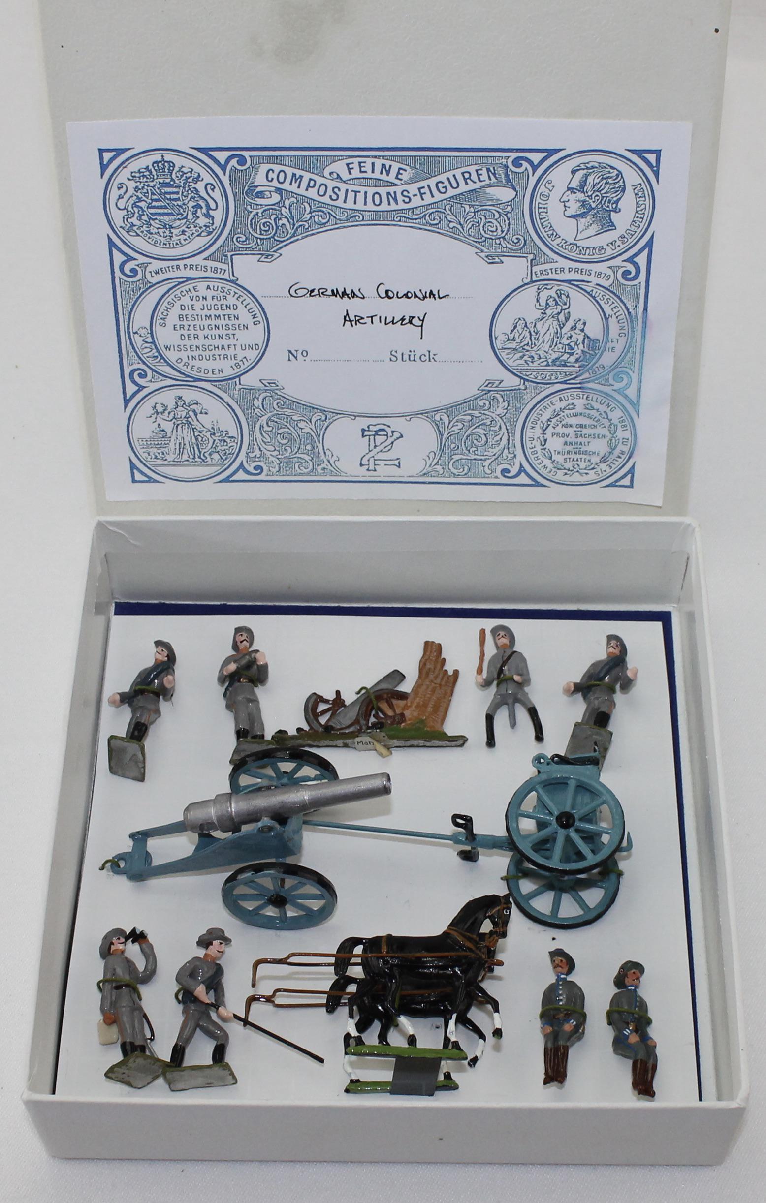 Potsdamer Zinnsoldaten Set German Artillery Crew: Heyde Recreations by Joe Shimek. Colonial German Artillery with Crew. 48mm. Includes Gun, Gunners and One Scenic Element. 12 Pieces. Condition Excellent. Box Very Good. Small Water Stain on Label.