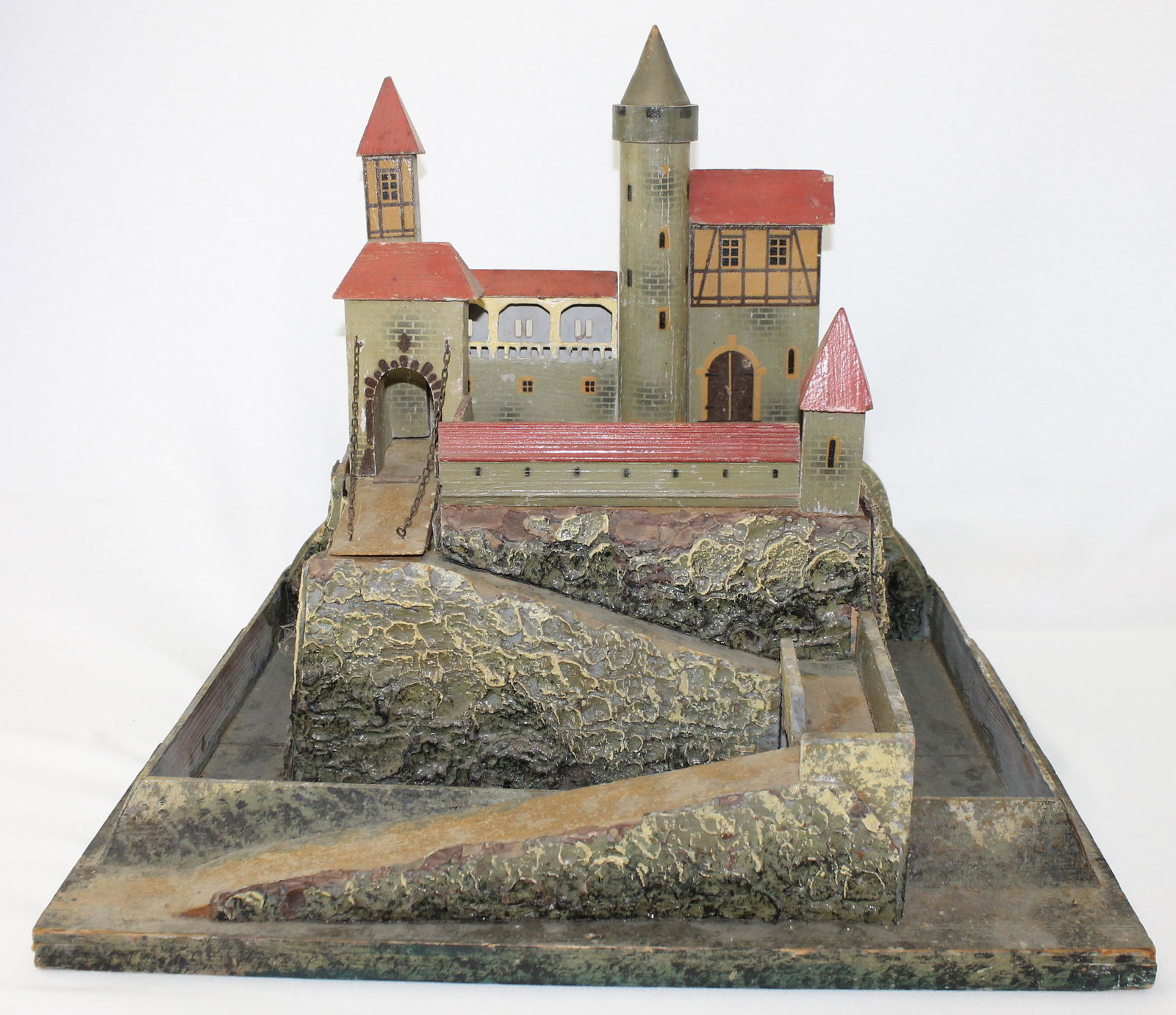 Gottschalk Castle: Germany, Circa 1910. Made of Wood with Painted Details. Castle Pieces Fit into Base. Measures 20" x 15" x 16" High. 11 Pieces. Condition Fair to Good. Some Age Cracks and Paint Wear to Bark Finish. Ho