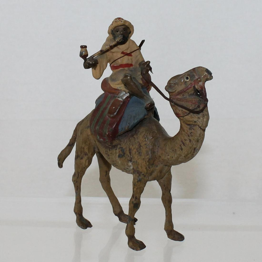 Heyde Large Size Souvenir Figure Arab on Camel: Figure of Arab Mounted on Camel Smoking Pipe with Rifle Slung Across Back. Measures 12cm Tall. 1 Piece. Condition Good to Very Good. No Box.