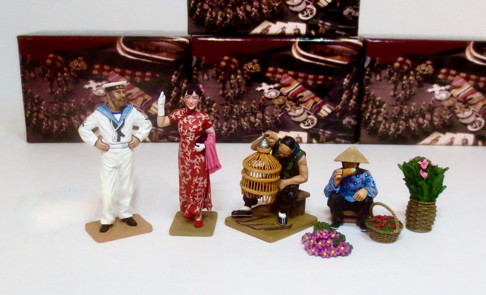 King & Country Streets of Old Hong Kong: Royal Navy Man #HK255, The Shanghai Lady in Red #HK257, The Bird Cage Maker #HK277, and The Hakka Flower Seller #281. 7 pieces. Mint condition. Boxes excellent.