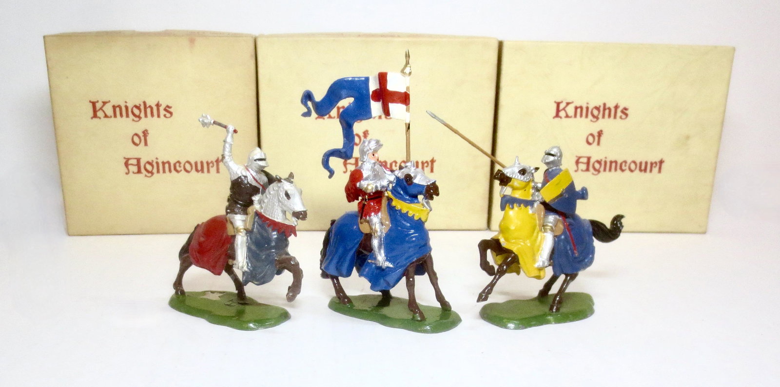 Britains Knights of Agincourt: Post war issue. #1659 Mounted Knight with Mace, #1662 Mounted Knight with Standard, and #9496 Mounted Knight with Lance. Near mint to excellent condition (paint loss on #1662 base). Boxes excellent to