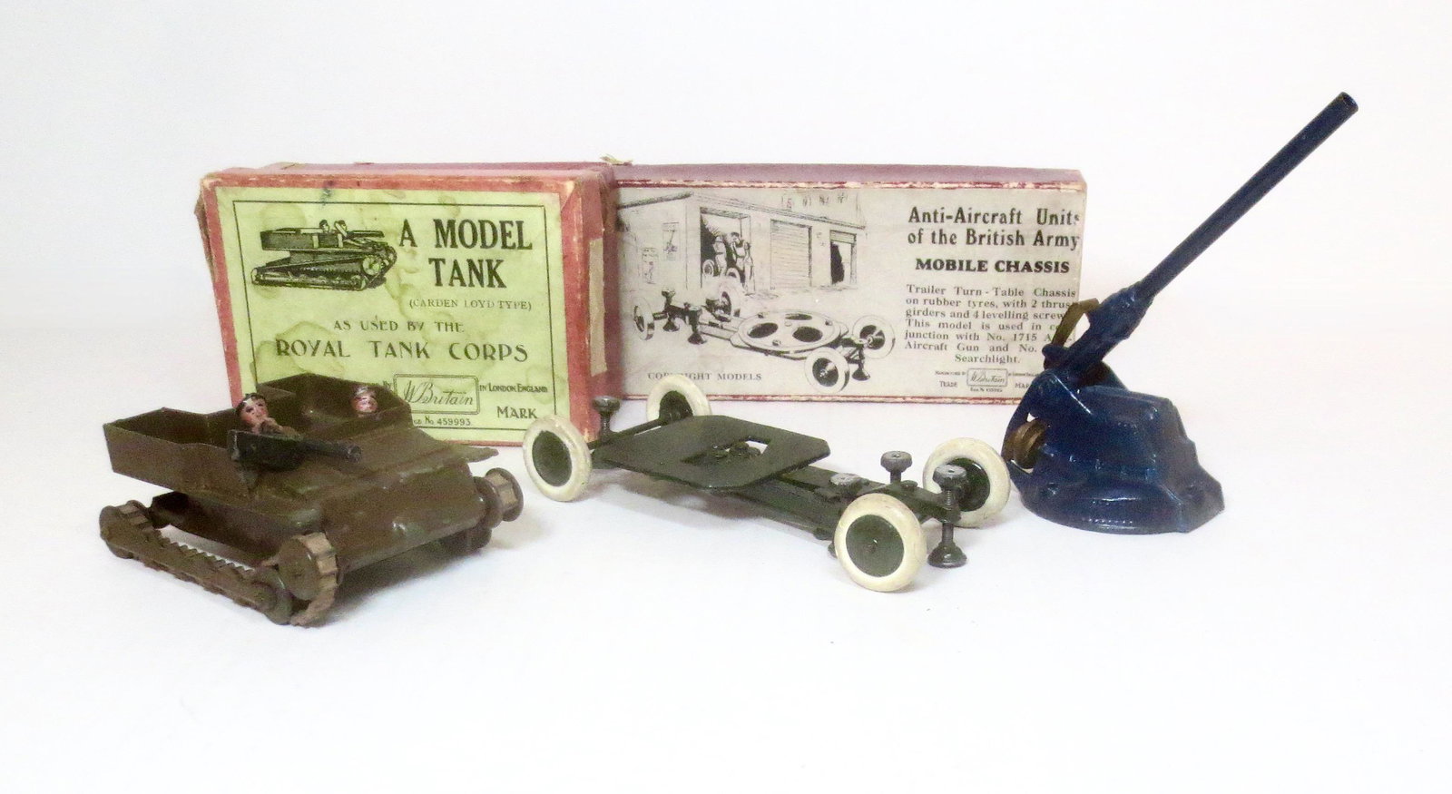 Britains Artillery Assortment: Cardon-Lloyd Tank #1203 in very good condition (one tread broken) with a box in poor condition. Anti-Aircraft Mobile Chassis #1716, in fair condition (missing circular part) with a very good box, and 