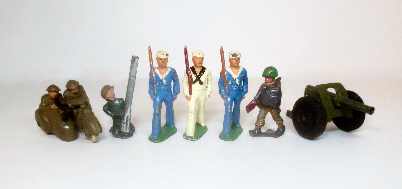 Assorted Dimestore Figures: Barclay Soldiers & Sailors with Field Gun and Auburn Rubber Motorcycle Combo. 7 pieces. Excellent to good condition.