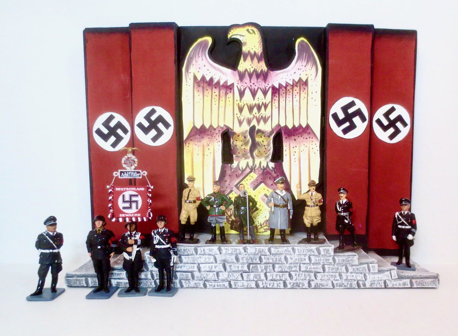 King & Country Nuremburg '38 Stage Display Set: With Six Axis Leaders (Hitler, Mussolini, Goering, Goebbels, Hess, and Himmler), Standard Bearer and other SS Figures. Mint condition. Stage Facade is Unboxed, Figures are in excellent boxed.