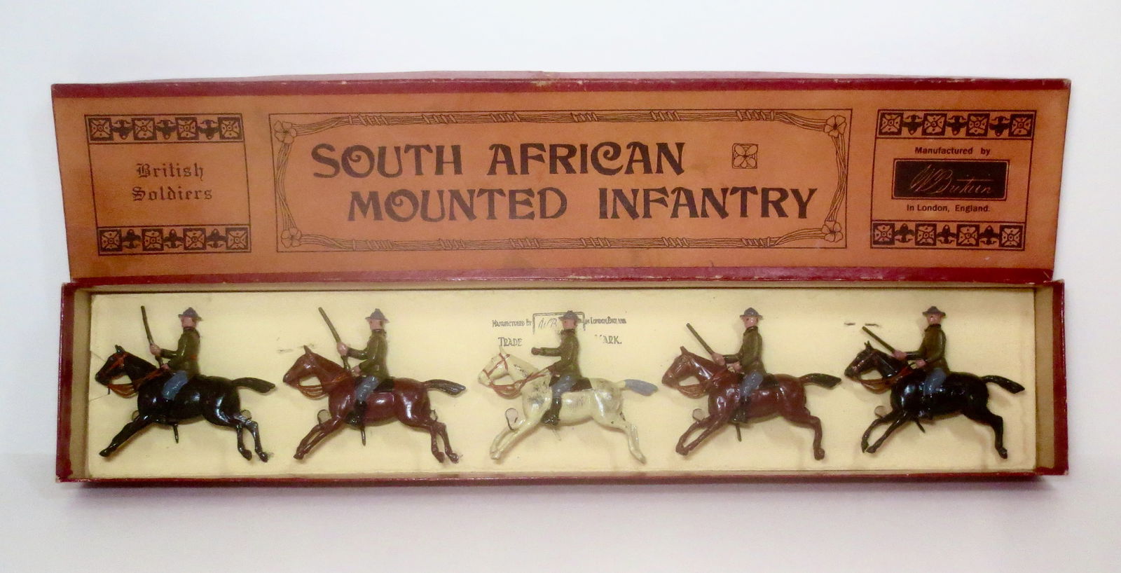 Britains #38 South African Mounted Infantry: Rare South African Mounted Infantry (1927 version), with empty handed Officer together with Troopers holding rifles. 5 pieces. Near mint condition, restrung in "British Soldiers" printed (orange) labe