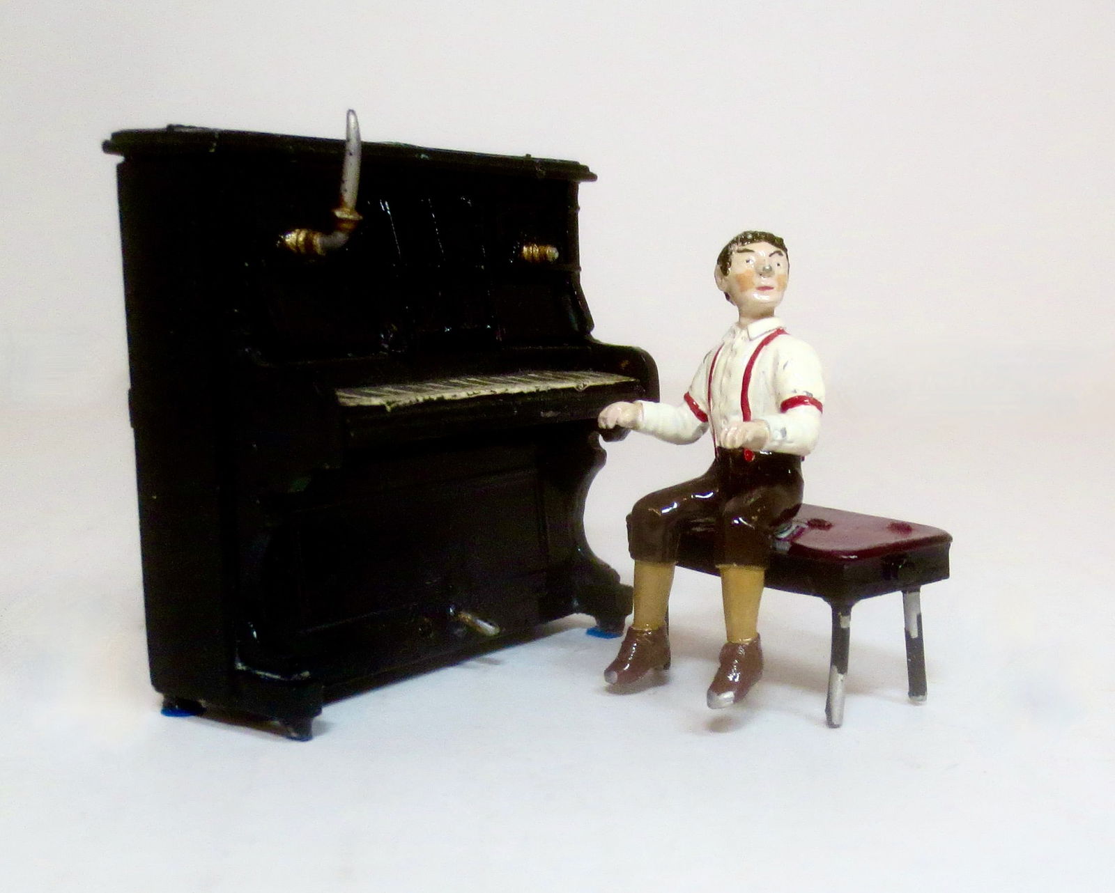 Unusual Boy Playing Piano: 50mm. 3 pieces. Excellent condition (some paint loss on piano bench). Unboxed.