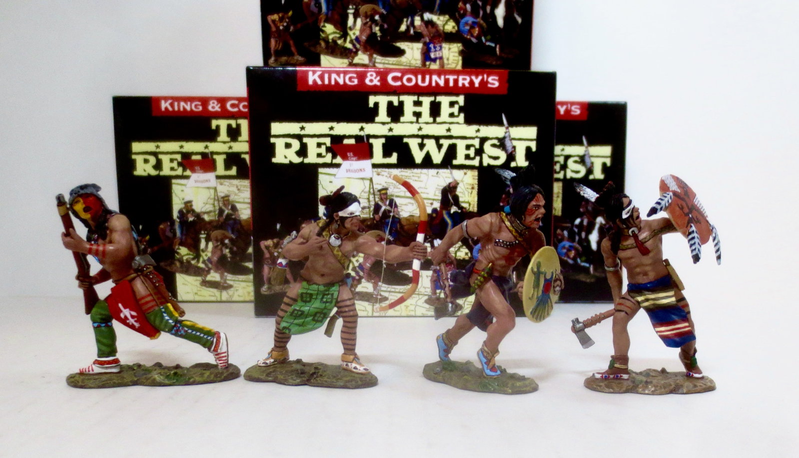 King & Country "The Real West" Figures: Running Warrior #TRW017, Charging Warrior with Axe #TRW0018, Warrior Firing Bow #TRW019, and Warrior Defending #TRW005. 4 pieces. Mint condition. Boxes excellent.