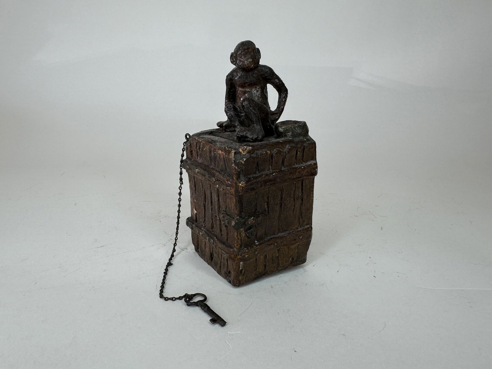 Elastolin Monkey on Trunk Still Bank: Composition with tin key lock and original key. 4.75" high. Condition excellent.