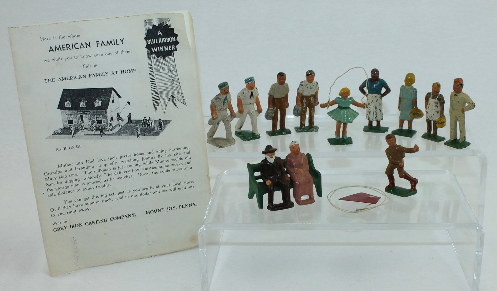 Grey Iron Lot American Family at Home: American Family at Home Series. Lot includes H 3 Boy with Kite, H 4 Girl Jumpimg Rope, H 11 Cook and Others with an Original Pamphlet. 14 Pieces. Condition Good to Very Good. No Box.