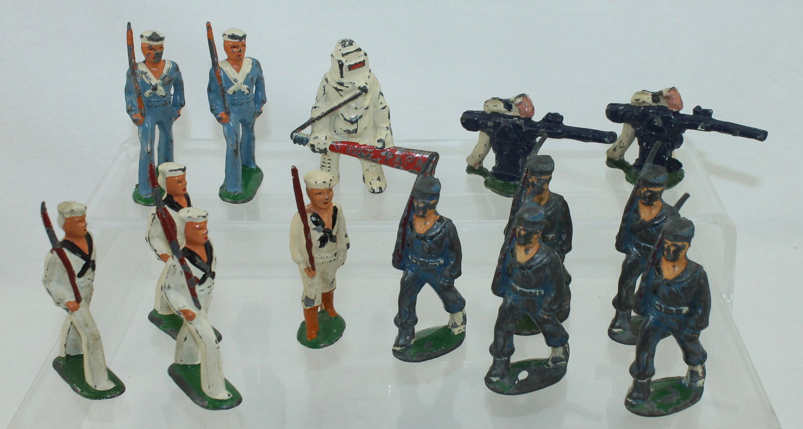 Manoil and Barclay Navy Lot: Includes Hot Papa Firefighter, 2 Naval Gunners and Hollow Base Sailors in Blue Uniform by Manoil and 4 Sailors in White and 2 Sailors in Blue by Barclay. 14 Pieces. Condition Fair to Good. No Box.