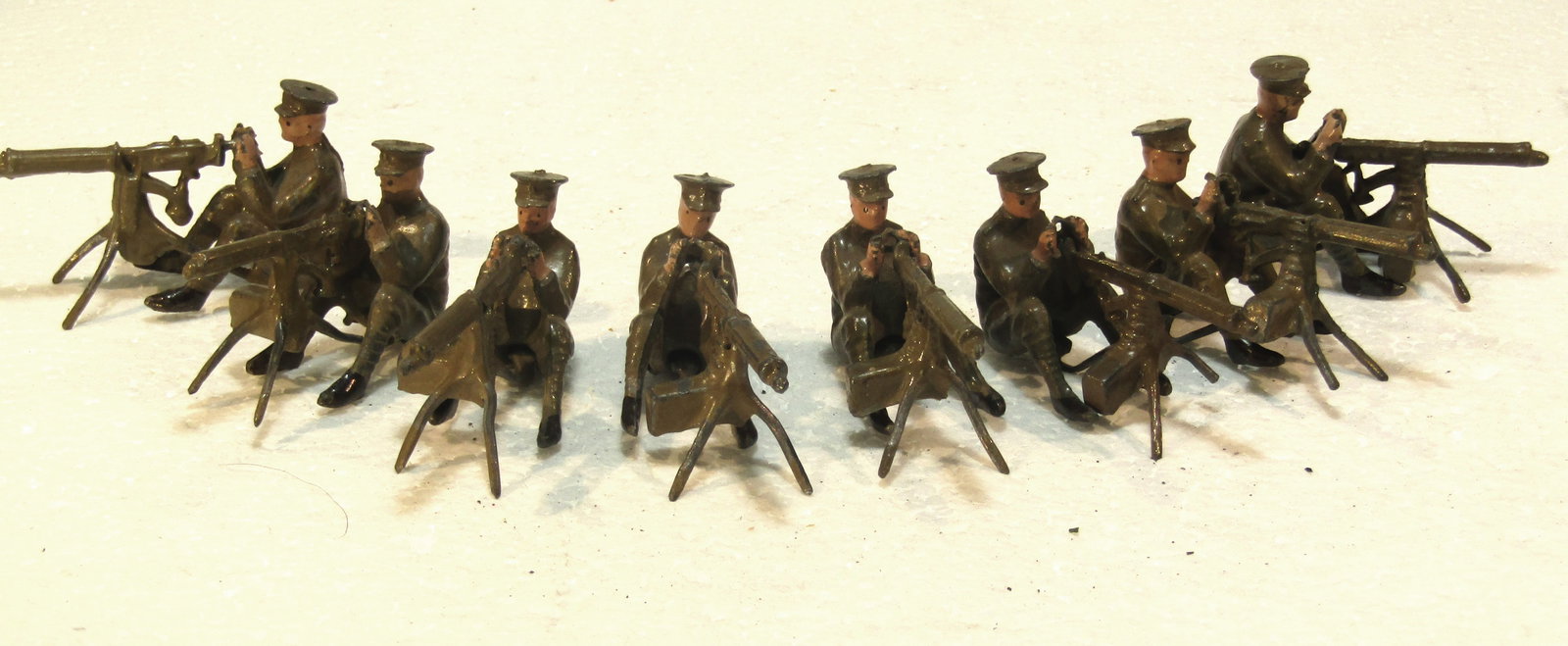 Britains No 198 British Army Machine Gun: Britains Ltd. # 198 British Army Machine Gun Section (seated, firing), 1st version (1919-1930's) in Khaki, and flat caps. Double set of 16 pieces total. Condition Very Good. Unboxed.