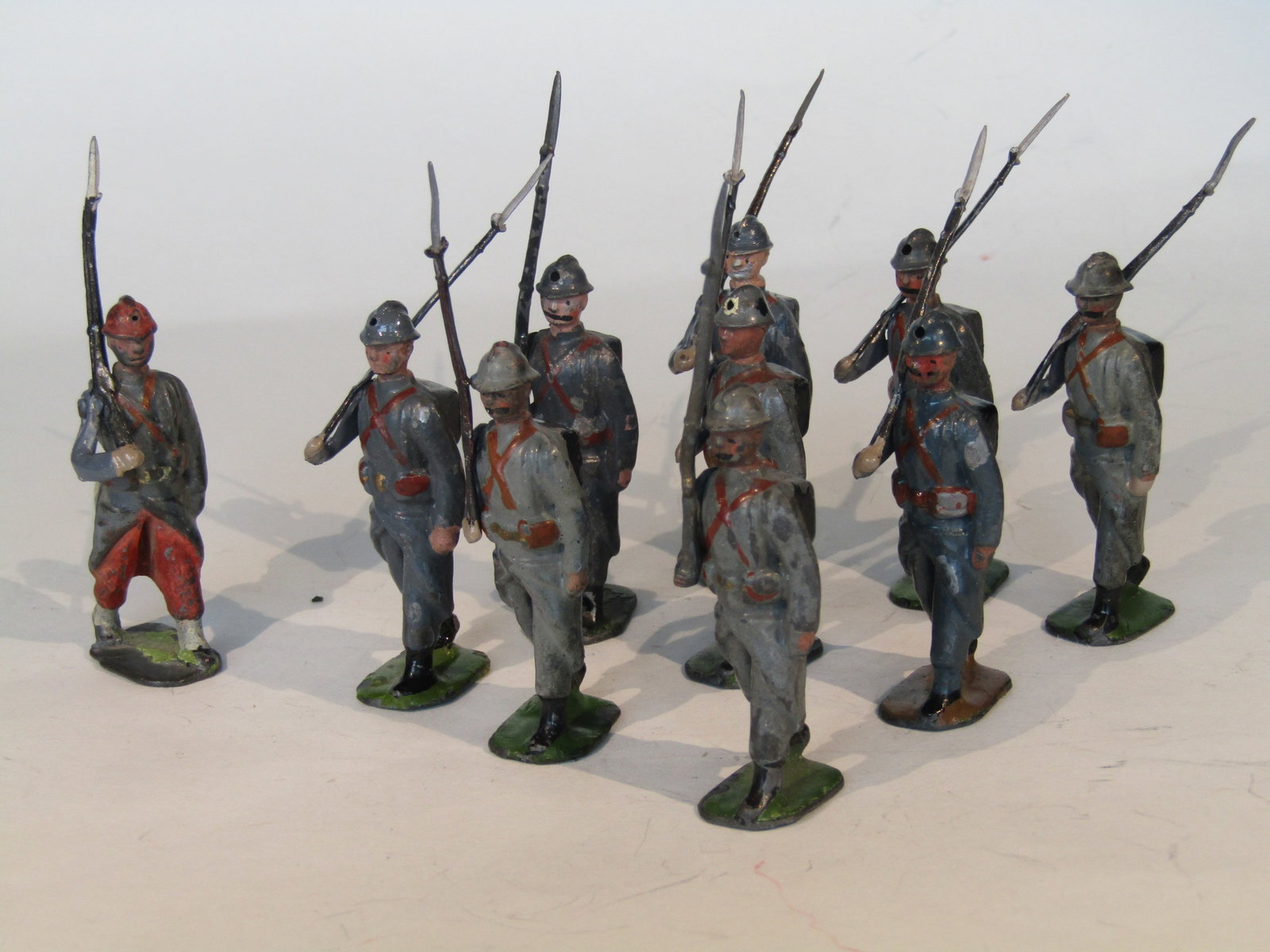 Britains Paris Office French Infantry: Britains Ltd. PARIS OFFICE French Infantry in French-Grey greatcoats with Adrian helmets. Rounded rectangular bases labeled with "Britains Ltd. DEPOSE". Contains 4 Paris Office figures from other Brit