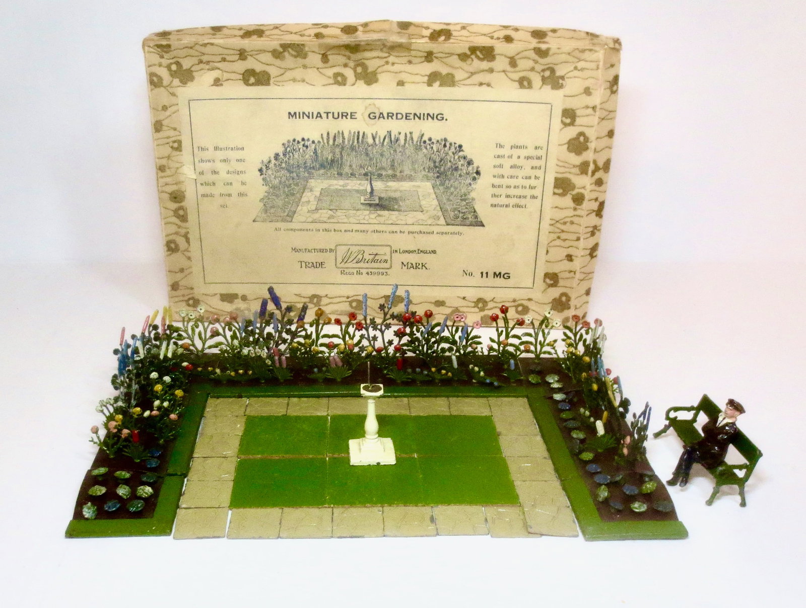 Britains RARE #MG11 Miniature Garden: Pre war, circa 1930. Plus a bonus dapper Johillco gent seated on a Britains bench for a lovely display. Pristine condition with original illustrated box. Box in very good condition.