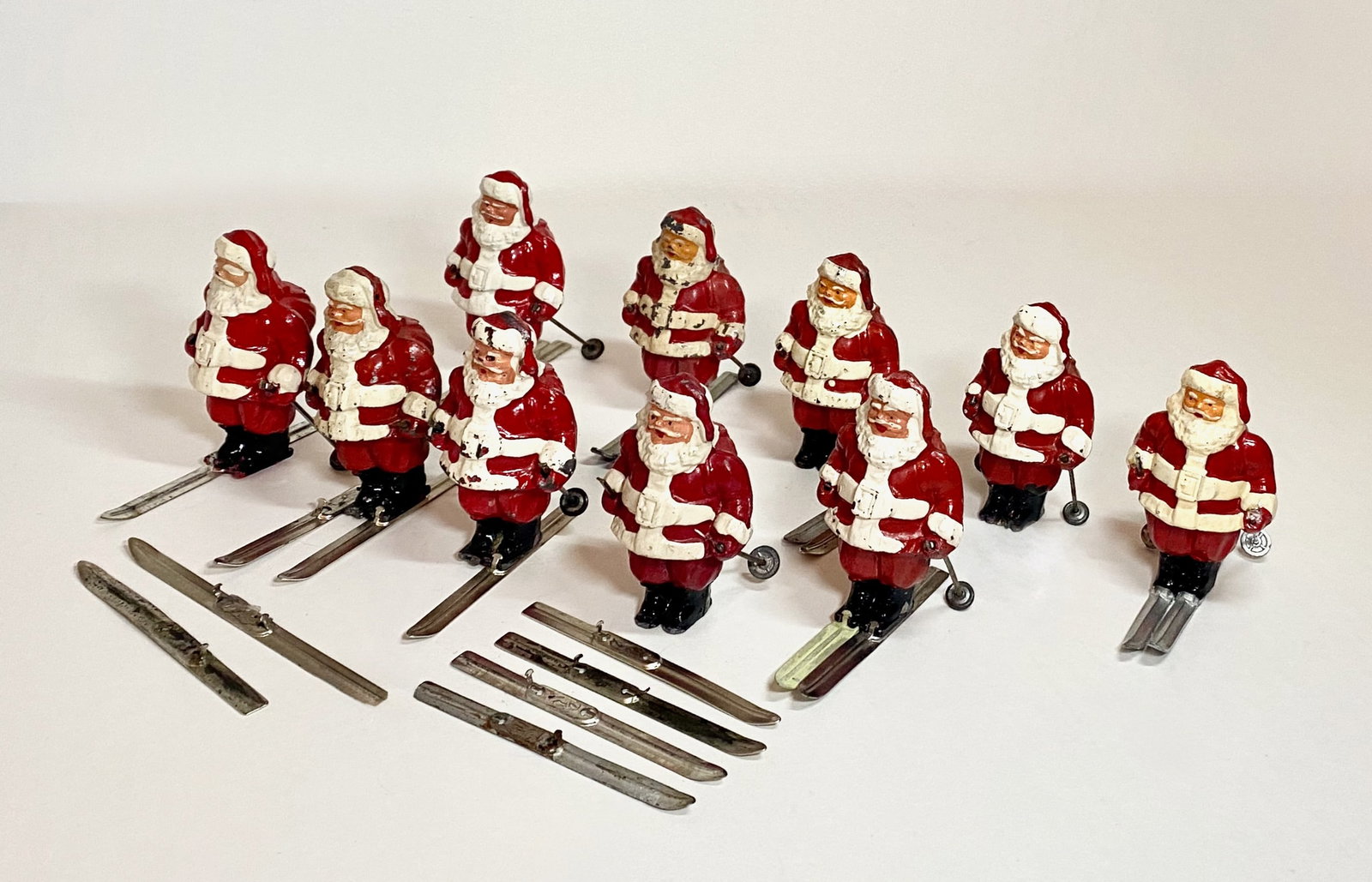 Large Lot of Santa on Skis: 10 pieces. Excellent to fair condition. Six with loose skis. Unboxed.