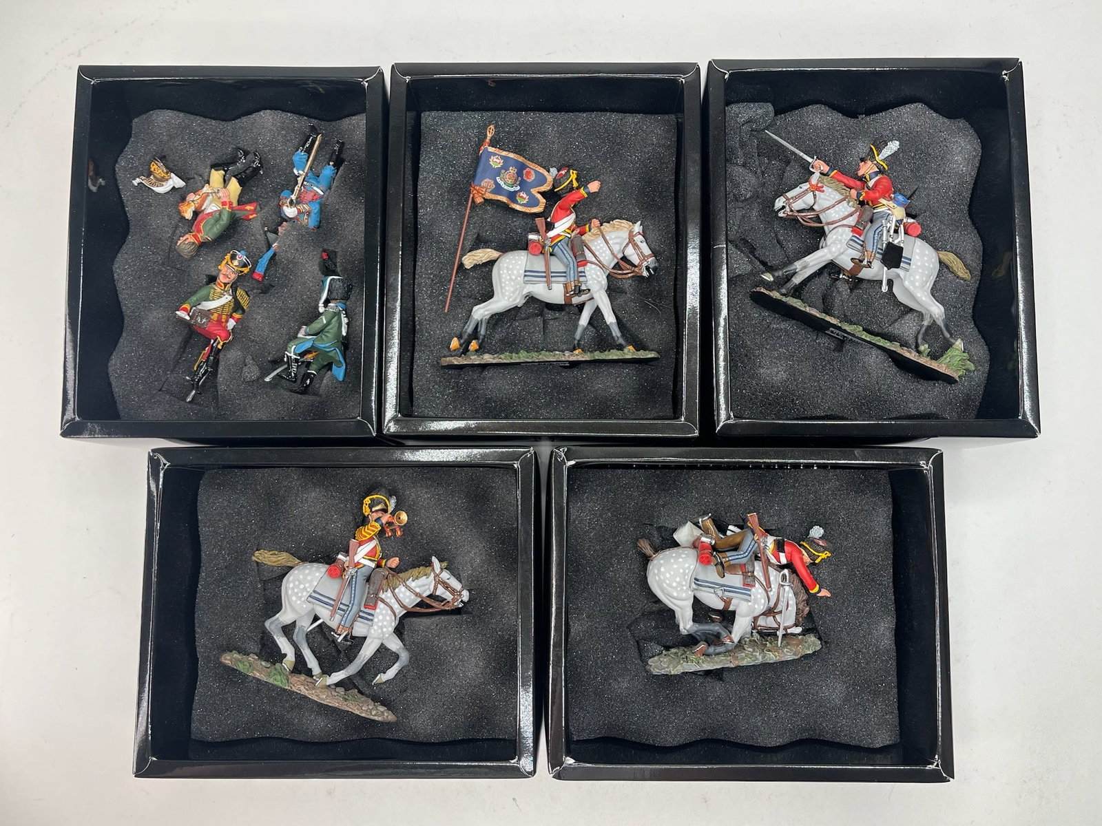 King & Country Napoleon Assortment Scots Greys: NA082 Seated French Cavalry (Figures Only), NA083 Scots Grey Standard Bearer, NA084 Scots Grey Bugler, NA085 Scots Grey Charging, and NA088 Collapsing Horse. 8 Pieces. Condition Excellent. Boxes Very 