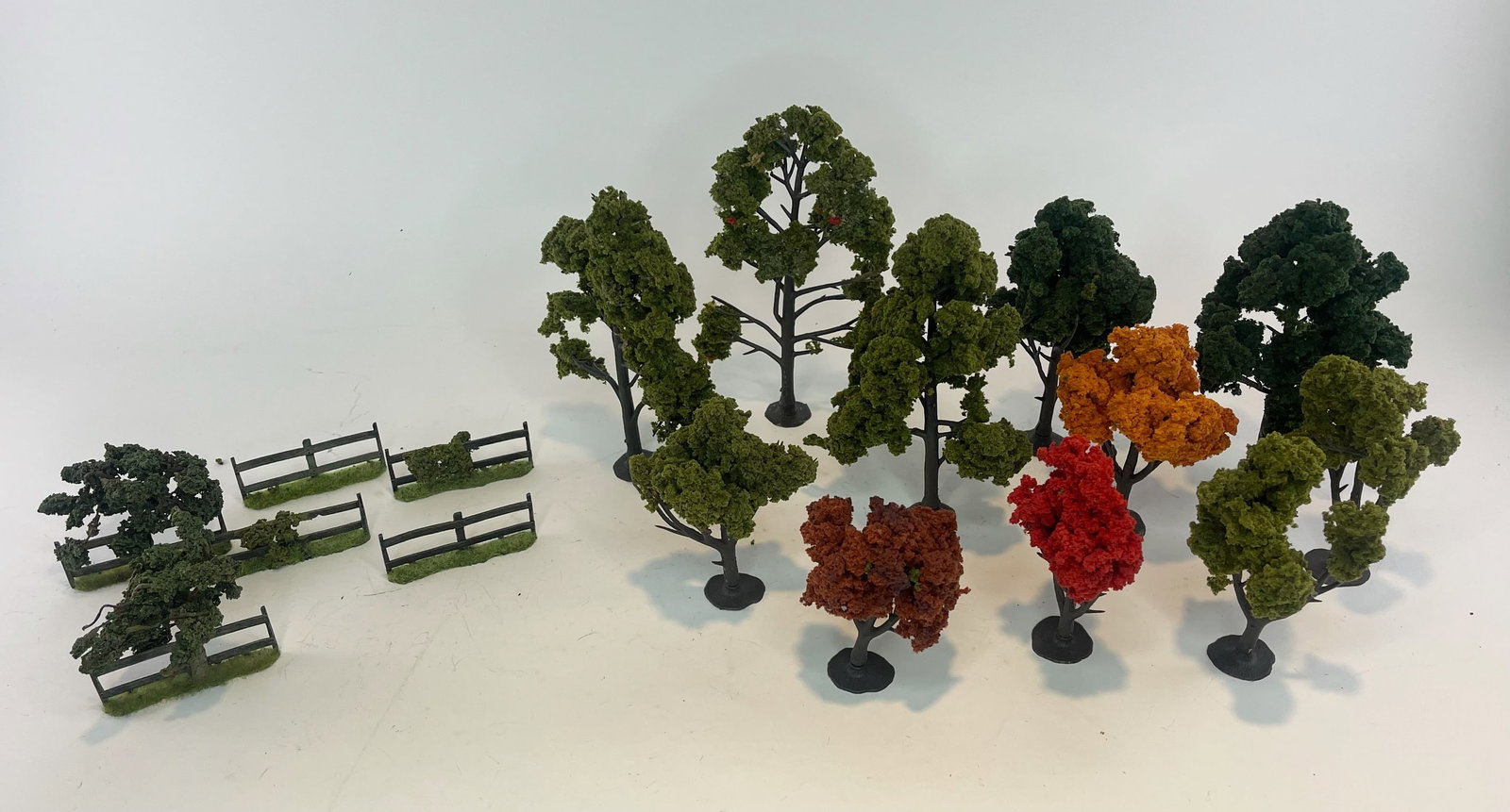 Tree and Fence Assortment: Unknown Makers. 6 Fences, 11 Trees. Trees range from 4 to 7.5 inches tall. 17 Pieces total. Condition Good to Very Good. No Box