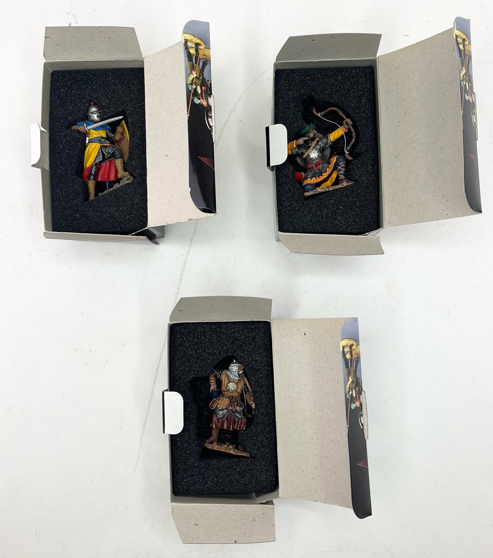 King & Country Crusaders and Saracens Assortment: Includes MK057 Sir Roger De Tolkinghorn, MK060 Kneeling Saracen Archer, and MK061 Loading Saracen Archer. 3 Pieces. Condition Excellent. Boxes Excellent, Some Glue Loose.