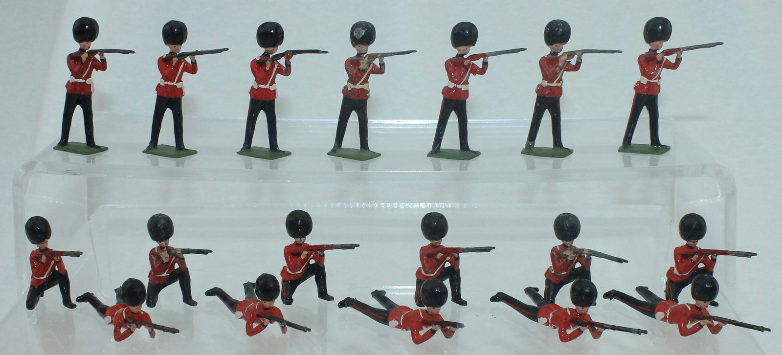 Britains Lot Grenadier Guards Firing: Lot includes 7 Standing, 6 Kneeling and 5 Lying Firing. 18 Pieces. Condition Good to Very Good. One Rifle Broken. No Box.