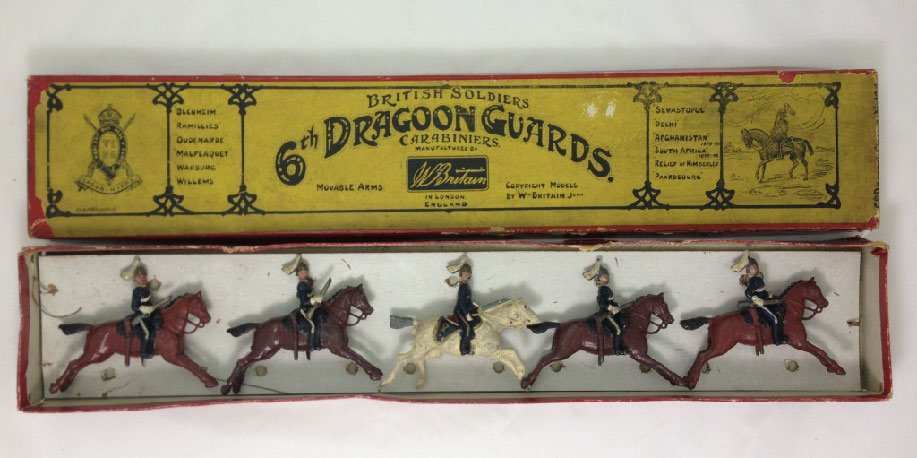 Britains Set #106 6th Dragoon Guards: With original box and tie card. 1st version. Circa 1904. Empty handed Officer. Troopers with short carbines. 5 Pieces. Condition: Very Good.
