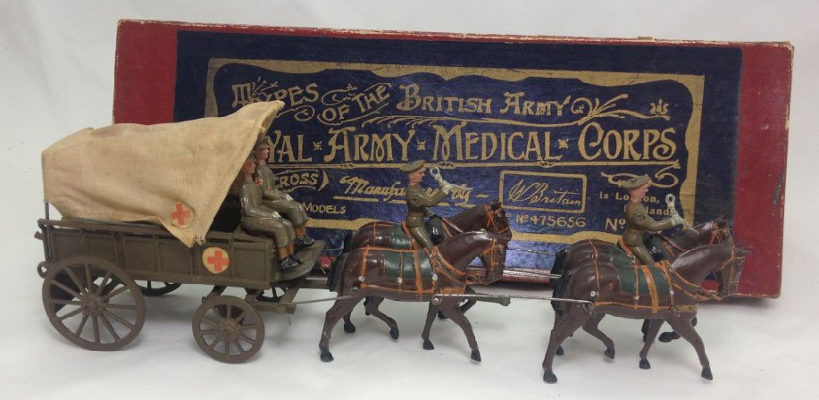 Britains Set #145A Royal Army Medical Corps: Royal Army Medical Corps Ambulance with original box. Light horse collars with peaked caps. Circa 1920. 7 Pieces. Condition: Excellent, with light wear to seated medics.