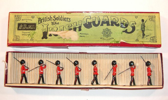 Britains: Set #107 Irish Guards: 7 Guards marching at the slope, 1 officer, blue flashes on bearskins, in original “Whisstock” Box (M, box F) [8] Provenance: Christie’s East, Lot 572, June 11, 1983.