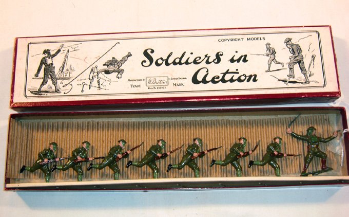 Britains: Set 1613 British Infantry in Action: 7 charging with rifles and gas masks, and one officer with pistol and sword, in early “Soldiers” box, (NM, Box G) [8]. Provenance: Christie’s East, Lot 411 March 3,1984. 1 riflebent.