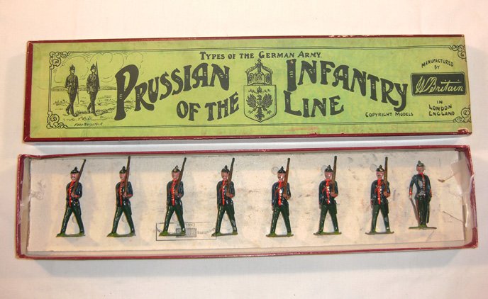 Britains: Pre-War, Set # 154 Prussian Infantry: 7 marching at the slope, with 1 officer with sword raised, in original “Whisstock” box (F, few chips, box VG.) [8].Mismatched officer.