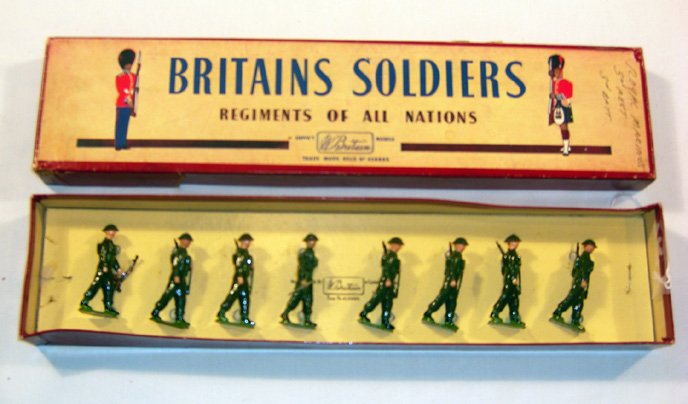 Britains: Set #1858 British Infantry: In Battledress. 6 marching with slung rifles, 1 with bren gun in left hand, 1 officer with baton in original “Regiments” box (NM, box F) [8]. Mismatched.