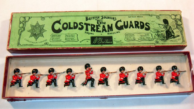 Britains: Early Set # 120 Coldstream Guards: Loose. 9 kneeling firing and 1 officer with field glasses kneeling, in original “Whisstock” box (NM, few chips box F) (10). No tie card.
