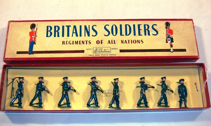 Britains: Set #2044 U.S. Air Corps: 1949 Uniforms 7 in blue uniforms with officer tied in original “Regiments” box ( M, box E,) (8). Two with applied Chevrons.