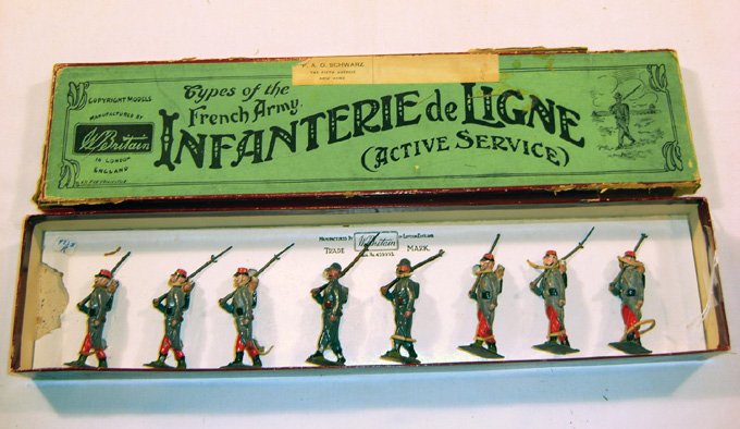 Britains: Assorted Infanterie de Ligne Figures: Pre-War. Two early shrapnelproof helmets, horizon-blue great coats, (1939) and 6 review order early Infanterie de Ligne, in Early “Whisstock” box #192 (G/F, some repaintingon faces on review order