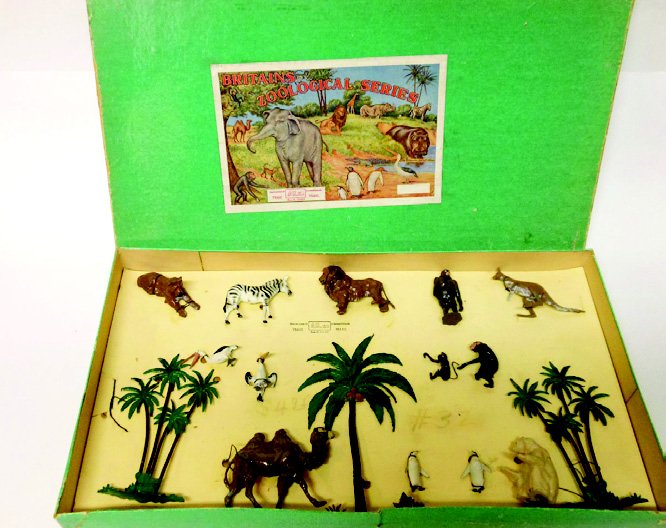 Britains Set # Zoo Display Set #3Z: Pre-War. Tied in Original Illustrated Box. 3 Palm Trees, 2 Pelicans, 2 Penguins, Chimpanzee, Climbing Monkey, Zebra, Lion, Lioness, Gorilla, Kangaroo, Seated Polar Bear, and Camel. 16 Pieces. Conditio