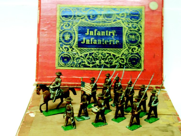 Gebruder Heinrick U.S. Infantry: Pre-War. 60 mm Khaki Infantry. In Original Wooden Sliding Top of Box with a label. Mounted Officer, Flag Bearer, Drummer, Foot Officer, and 8 Men. Total of 13 Pieces. Condition Excellent, Box Very Goo